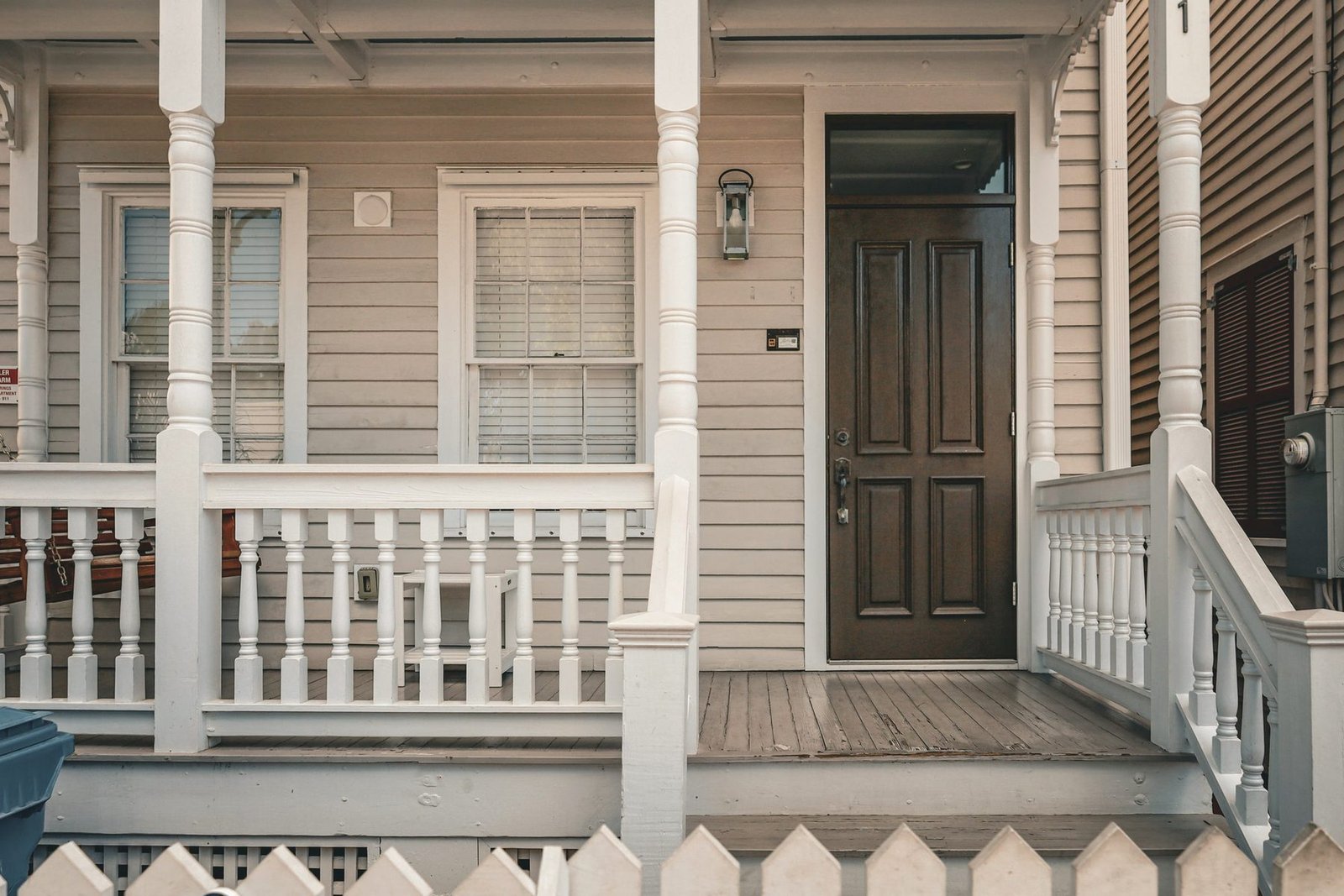 The front porch and door of a white clapboard house.