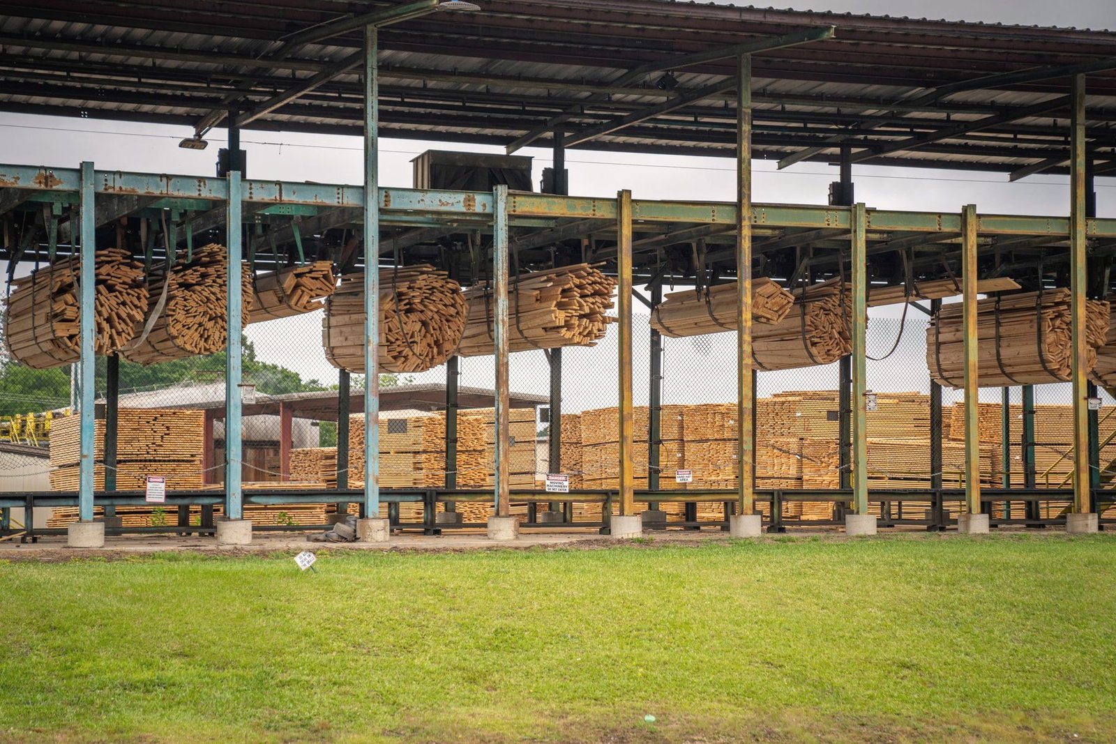 Long racks of stacked sawn timber under an open shed.